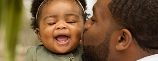 Dad kissing baby on the cheek